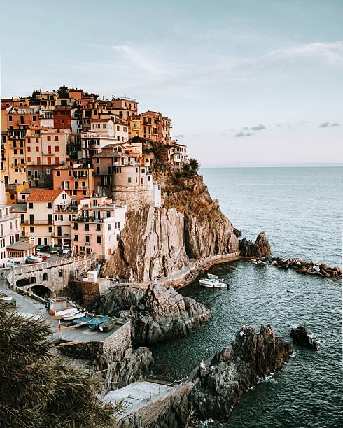 Colorful houses perched on a cliff overlooking the sea in Manarola, Cinque Terre, Italy, showcasing stunning coastal architecture and landscape.