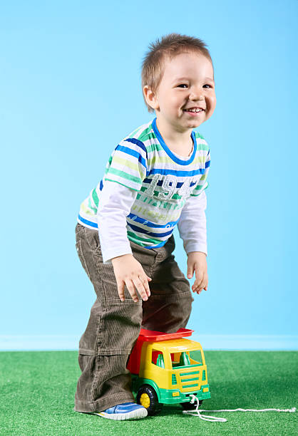 istock Funny little boy having fun playing with a car 2218458148