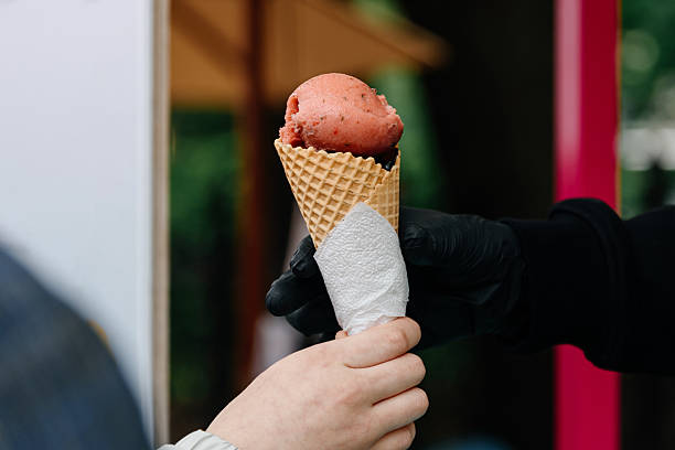 istock seller passes ice cream cone to buyer 2218458978