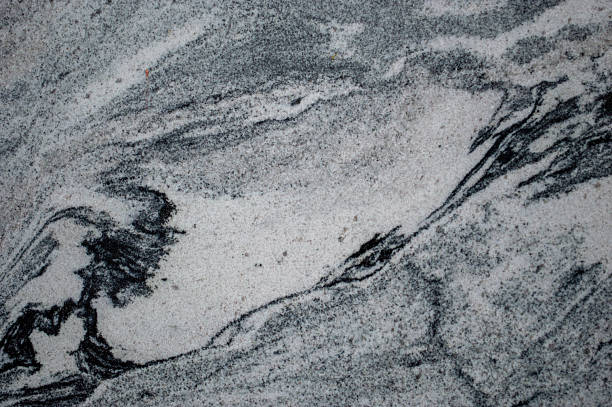 This close-up view reveals a stunning black and white marble surface marked by swirling patterns and textures, making it visually striking