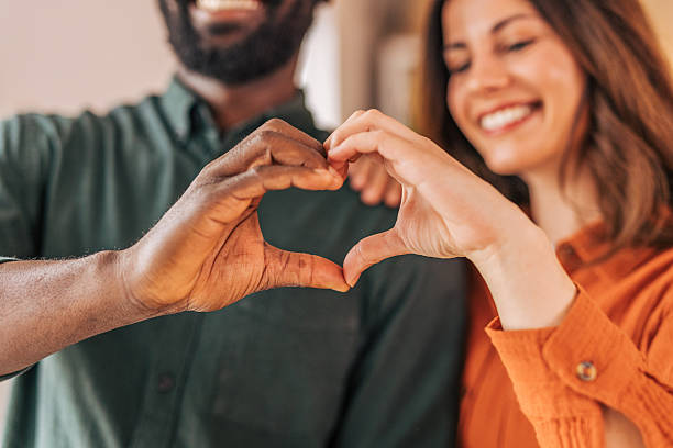 istock Interracial couple making heart shape with hands 2218464087