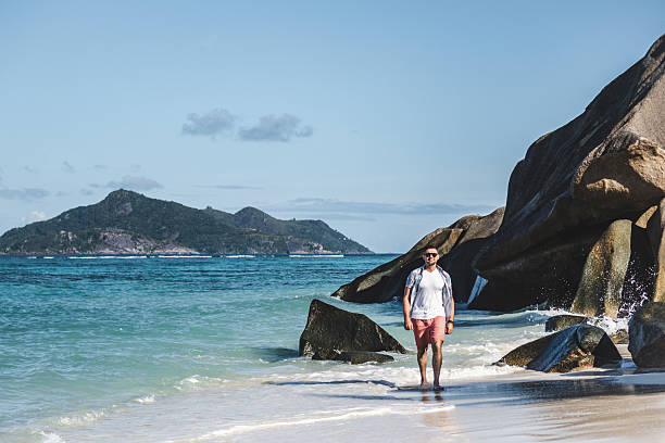 istock Attractive man walking on stunning white sand beach 2218464096