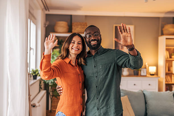 istock Happy multiethnic couple waving hands at home 2218464200