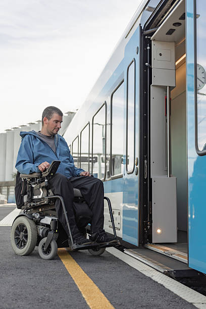 istock Man with a physical disability, an electric wheelchair user entering a train 2218465665