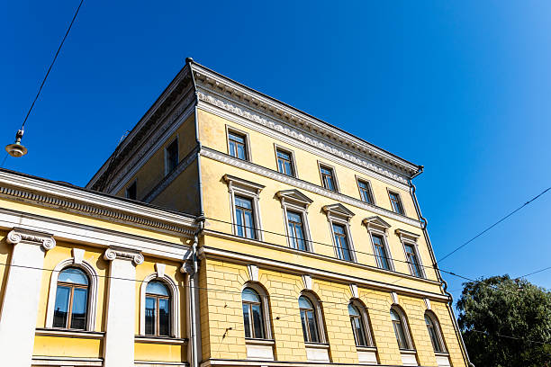 istock Bright yellow building in Helsinki, Finland, viewed from a low angle against a clear blue sky. 2218466180
