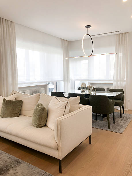 istock Contemporary open living space with cream sofa, green dining chairs and soft daylight 2218467293