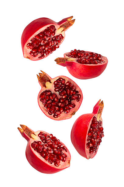Falling Pomegranate fruit isolated on white background with clipping path, full depth of field
