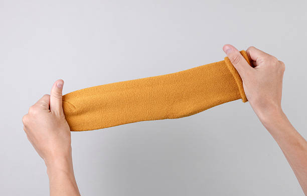 Female hands holding socks on gray background