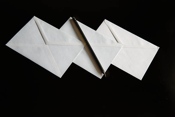 istock Envelopes and a black pencil on a black background. The minimalist image with a focus on aesthetics is suitable for fashion brands, graphic projects, or art galleries. 2218474749