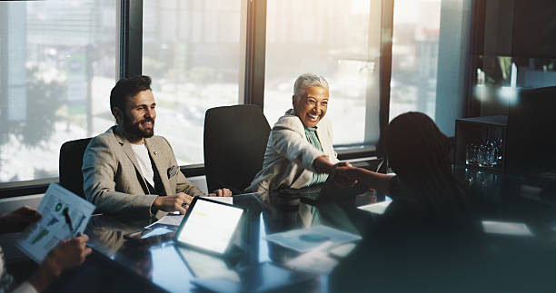 istock Meeting, handshake and people with documents, boardroom and discussion for stats, team and company. Corporate, colleagues and shaking hands for performance of business, happy and gesture for success 2218477059