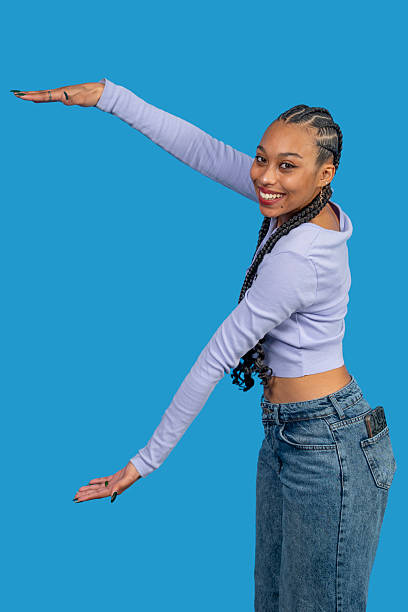 istock Young woman gesturing with open hands on blue background 2218478439