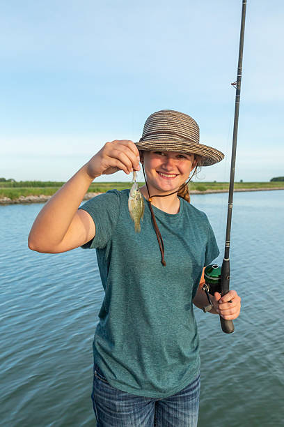 istock Girl Holding Small Fish She Caught While Fishing 2218478964