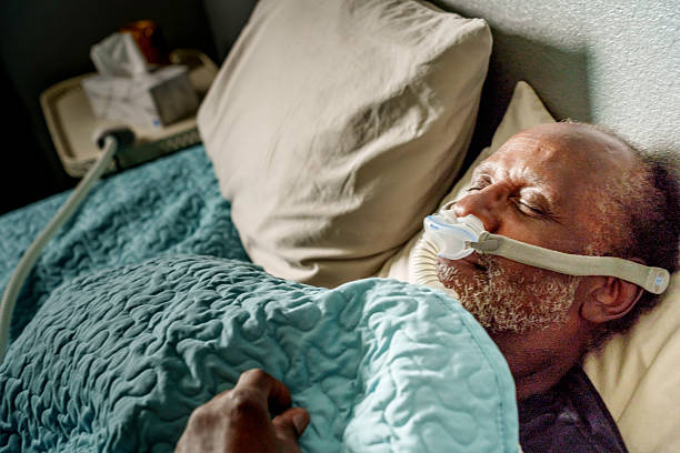 istock Older African American Male Sleeping with CPAP Machine in Bed 2218479624