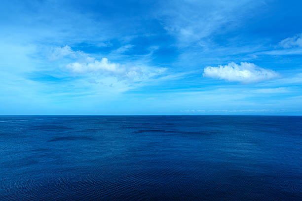 A tranquil Mediterranean ocean view displaying deep blue water under a bright sky with light clouds. The serene environment highlights nature's beauty and inspires feelings of peace and relaxation.