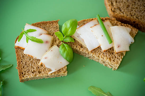 Sandwich with lard on rye bread and green onions on top.