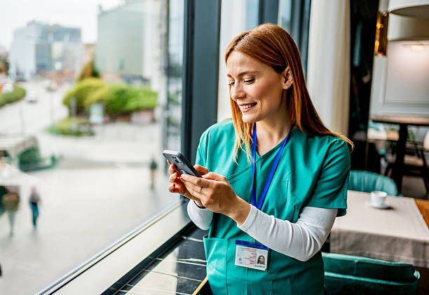 istock Happy nurse using smartphone on break at hospital cafeteria 2218483623