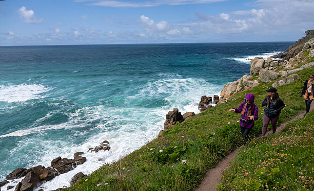 istock Young women hike pathway above ocean 2218484321