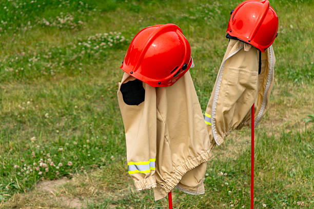 Junior firefighter uniforms from the Polish Youth Firefighting Team (MDP) displayed on stands with red helmets.