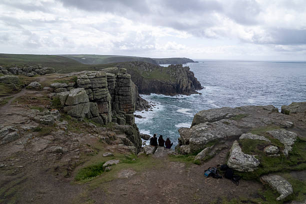 istock Friends sit on rock above ocean and cliffs 2218486057