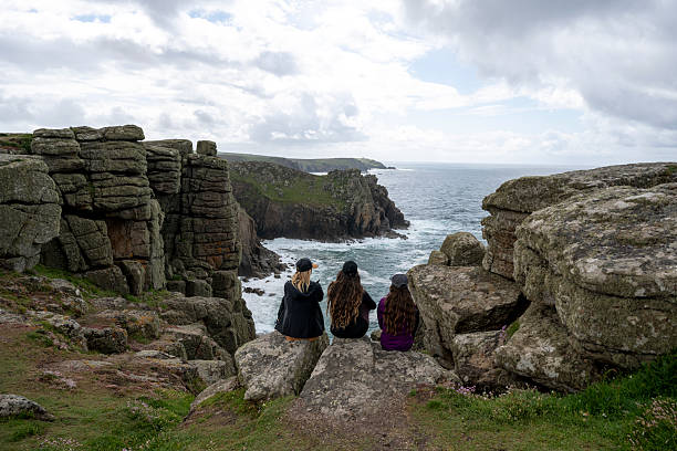 istock Friends sit on rock above ocean and cliffs 2218486060