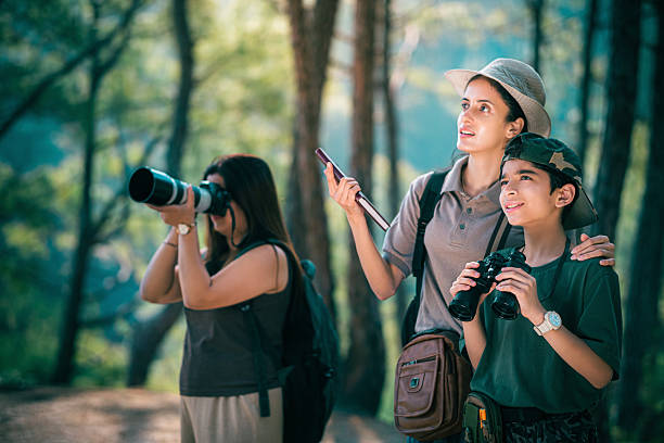 istock Female birding guide with mother and son on a forest birdwatching trip. 2218486190