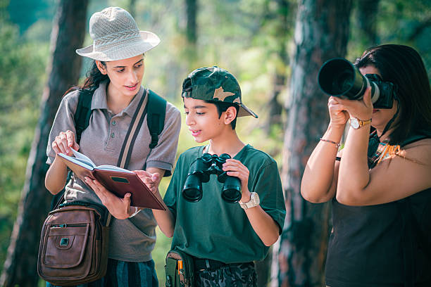 Female birding guide with mother and son during forest birdwatching trip