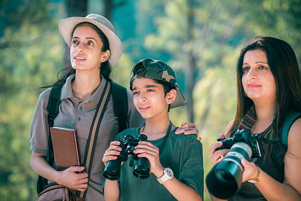 istock Female birding guide with mother and son during forest birdwatching trip 2218486194