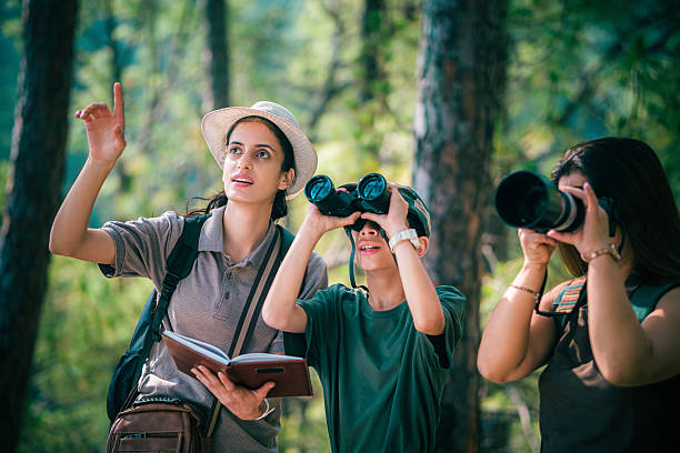 istock Female birding guide with mother and son on a forest birdwatching trip. 2218486196
