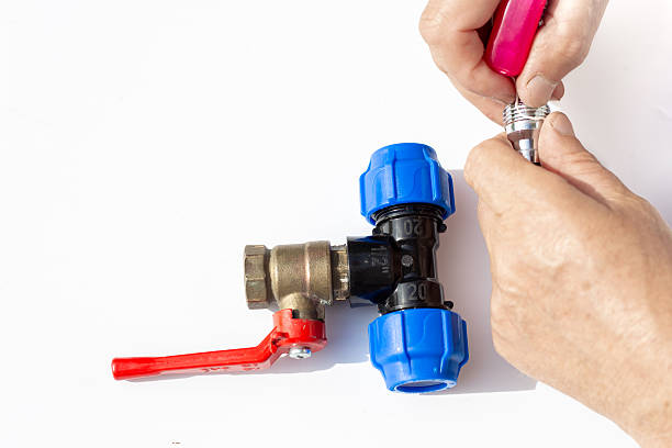 istock man's hand assembling plastic fitting with metal valve on white background. Plumbing repair 2218486441