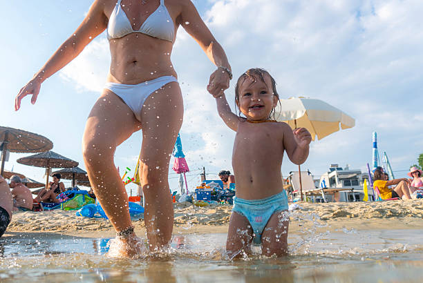 Mom runs into the sea with her daughter.
