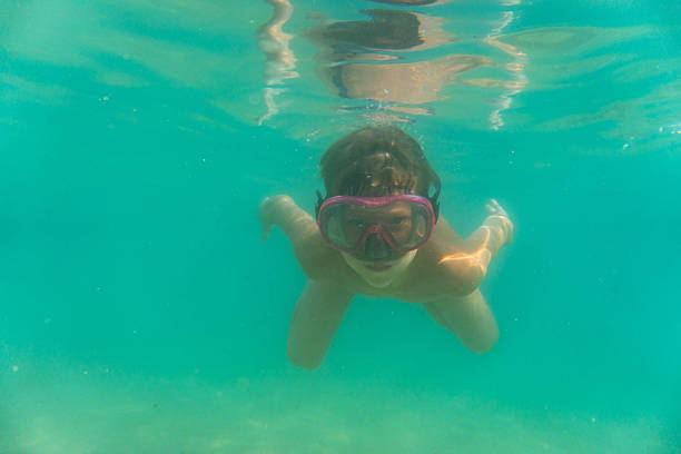 a boy dives with a diving mask in the sea