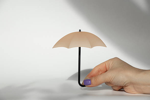 istock Miniature umbrella in a woman's hand on a white background 2218488230