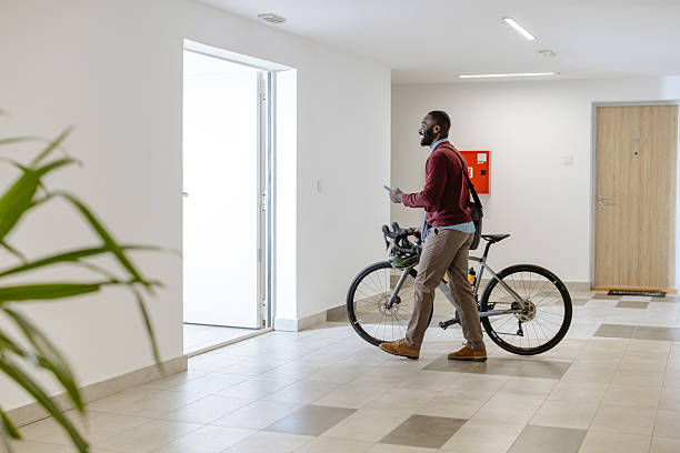 istock Man walking with a bicycle indoors in a modern apartment hallway 2218490022