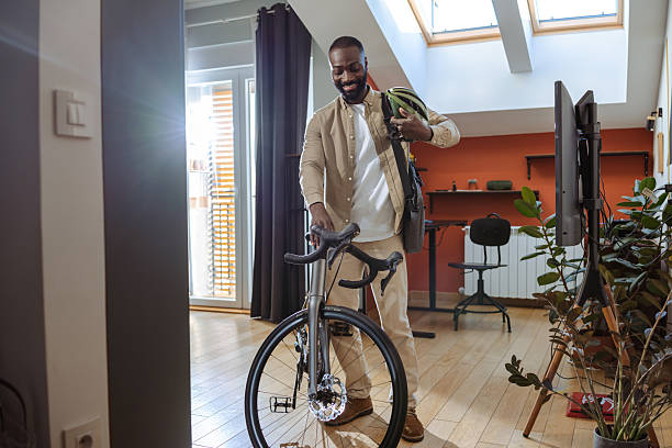 istock Man preparing his bicycle indoors in a modern living space 2218490065