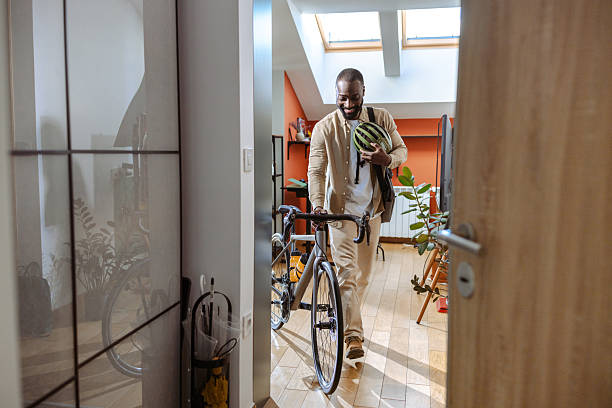 istock Smiling man leaving home with a bike and a work shoulder bag 2218490067