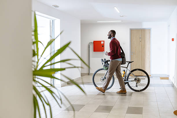 istock Man walking with a bicycle indoors in a modern apartment hallway 2218490513