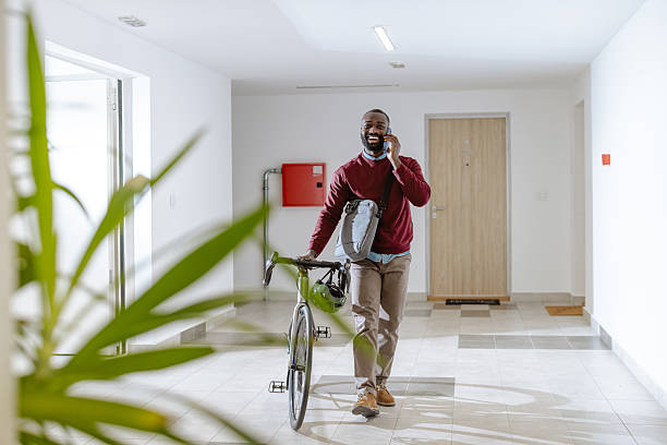 istock Person talking on phone while walking with a bicycle indoors 2218490536