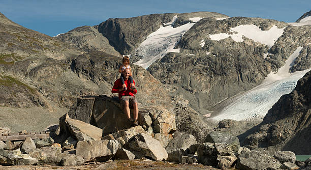 istock Father and young daughter sit on rock in alpine 2218496547