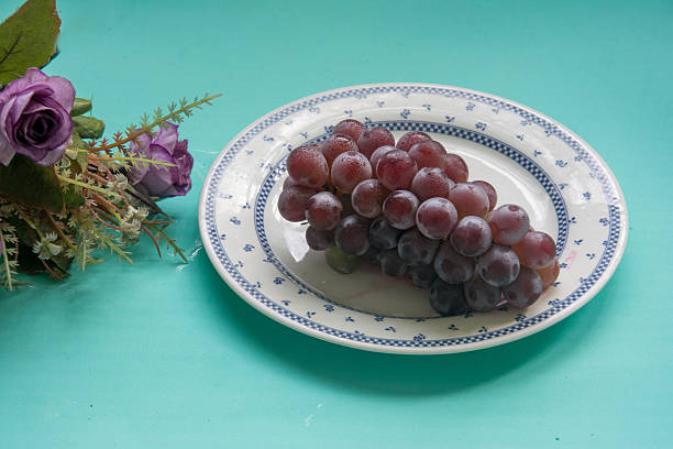 istock grape on a white plate with purple flower 2218498634