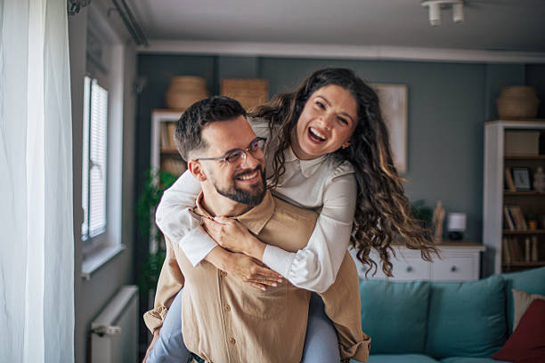 istock Young couple having fun piggybacking at home 2218502140
