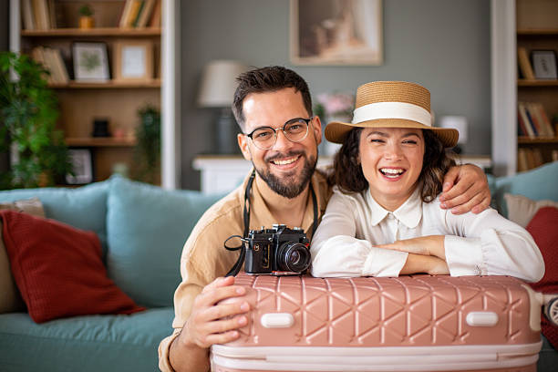 istock Happy couple smiling and leaning on suitcase ready for vacation 2218503411