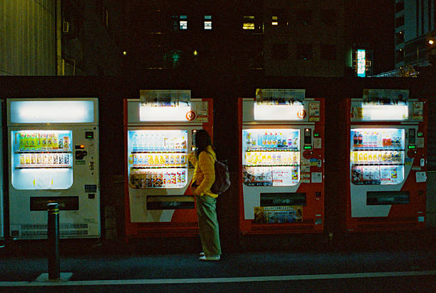 Woman buying from vending machine  during experiential trip to  Japan. Shot on camera film