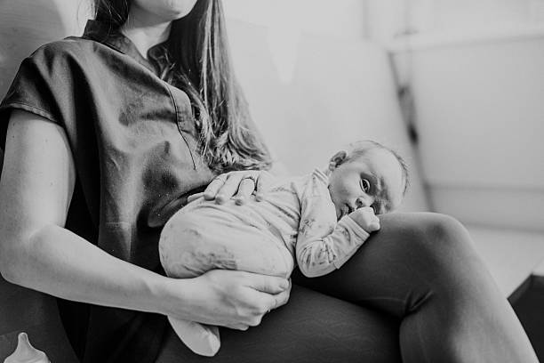 istock Sleepy infant resting on mother's lap 2218505698