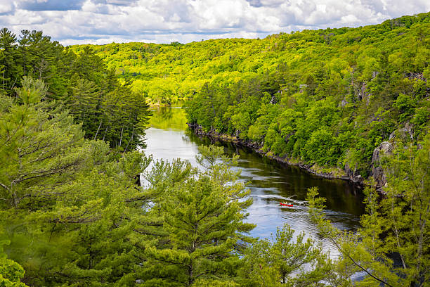 A trailer carrying a variety of colorful canoes awaits paddlers for a day of canoeing.