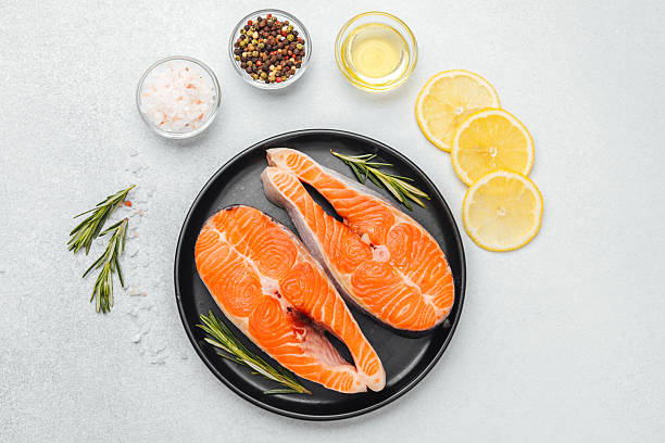 istock Fresh salmon fillets ready for cooking with herbs and lemon slices 2218510561