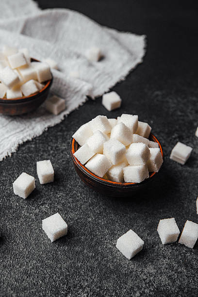 istock Sugar cubes in rustic bowls arranged on a dark stone surface 2218510605