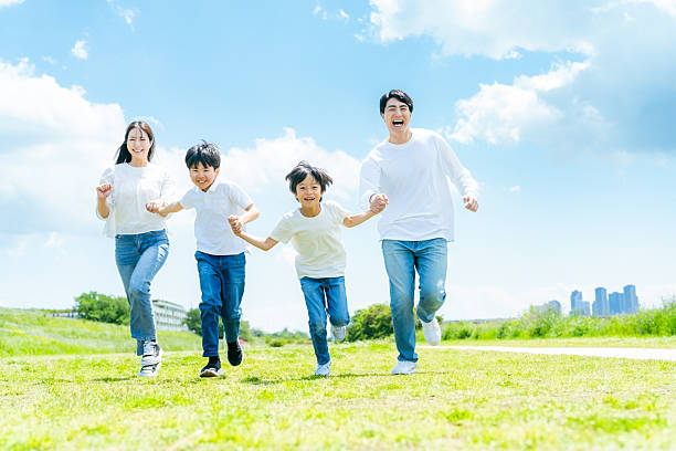 istock A family running on a meadow with blue sky 2218514169