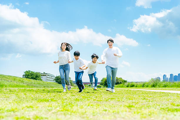 istock A family running on a meadow with blue sky 2218514178