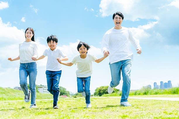 istock A family running on a meadow with blue sky 2218514179