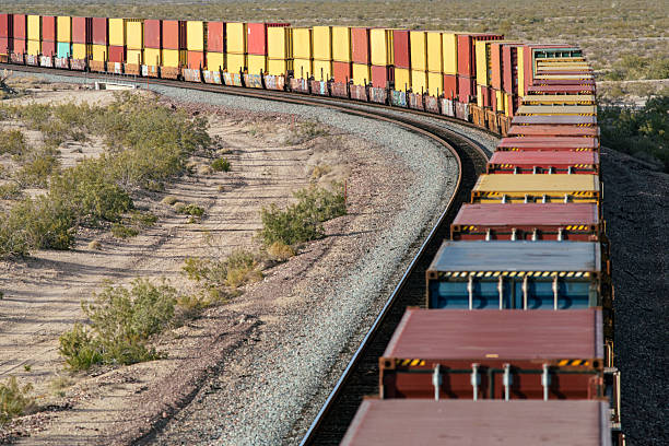 istock Long row of containers on train curving out of frame 2218518248